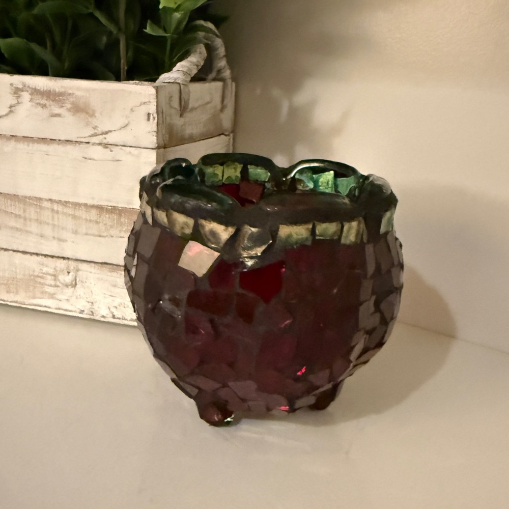 Mosaic Red Glass votive candle holder w/a dark green rim & three small feet.